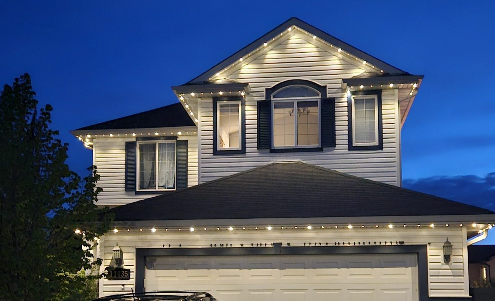 Edmonton home with permanent lighting at dusk