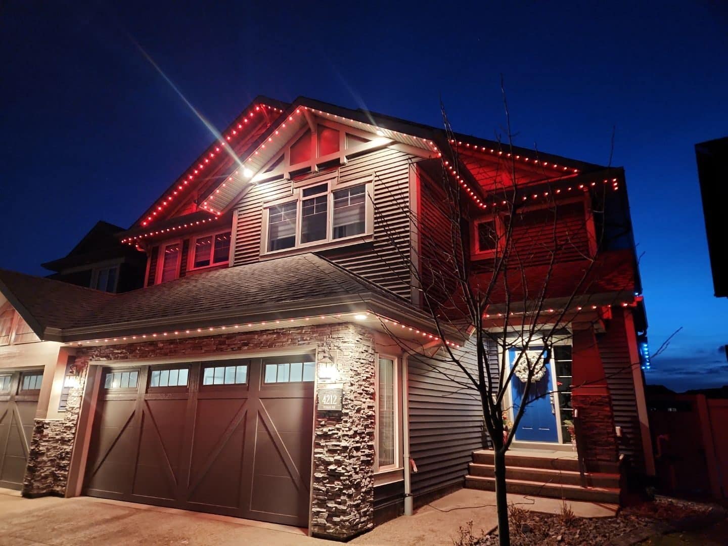 Two-story home lit red at night